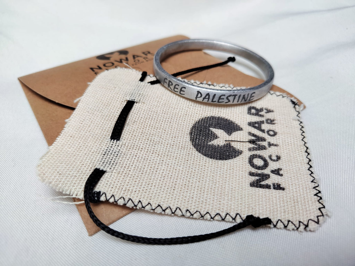 bracciale in alluminio con packaging ecosostenibile e la scritta Free Palestine