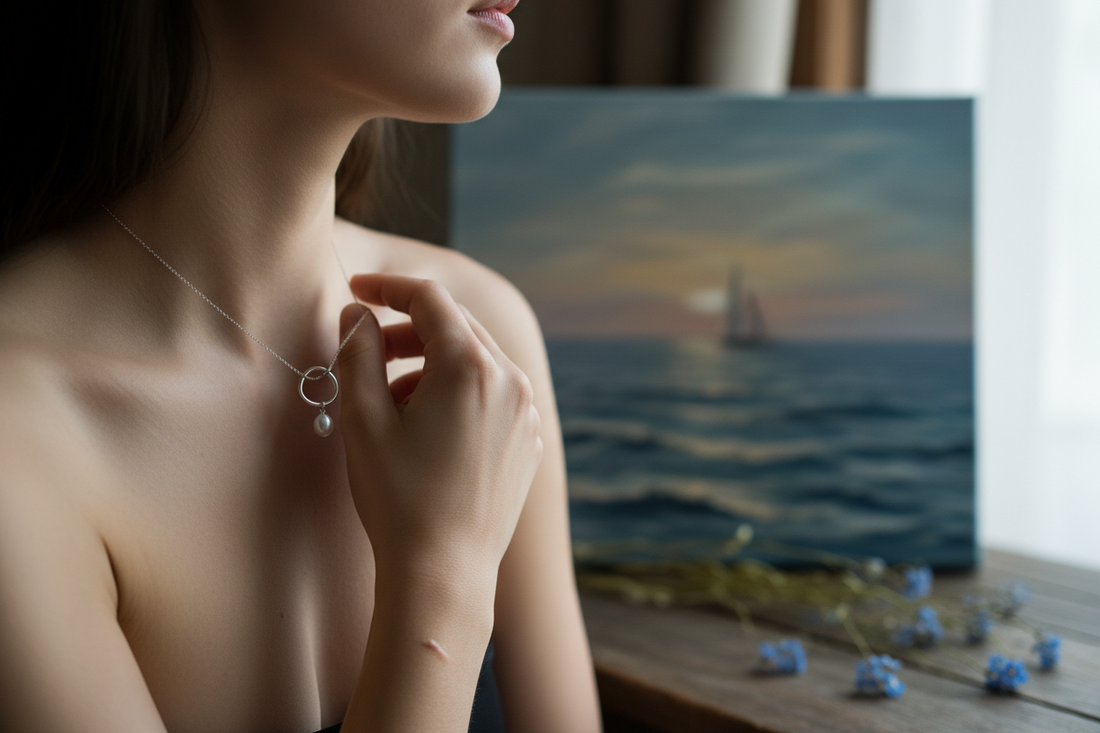 modella che guarda all'orizzonte toccandosi il pendente della collana realizzato con materiali riciclati